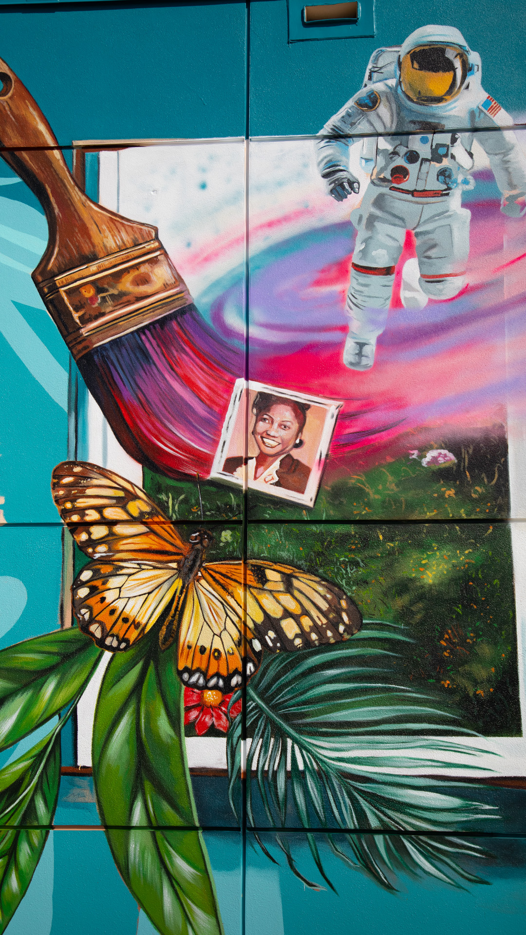 Exterior wall mural close up showing butterfly and paintbrush.