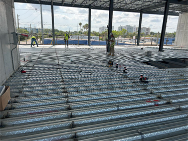 Interior of new city hall under construction showing workers laying the flooring.
