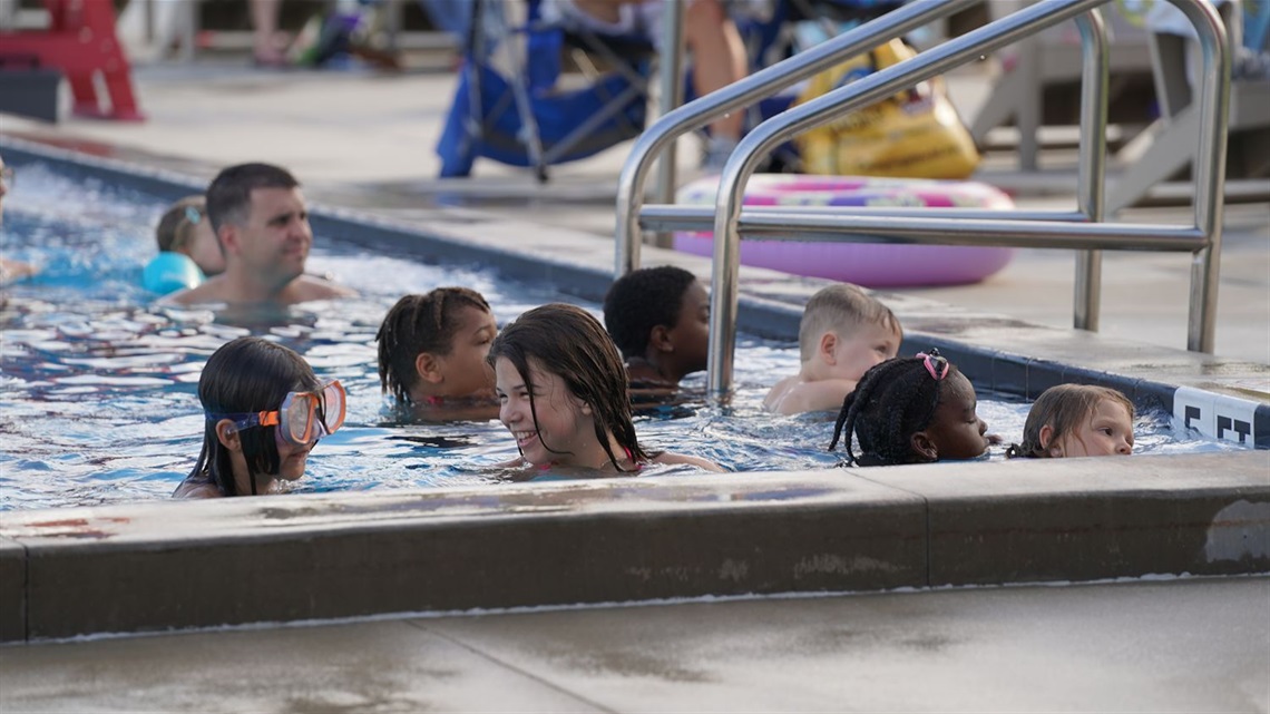 Group of Kids in a Pool, one smiling at the other.JPG