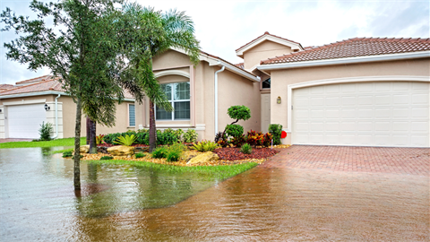 Image of house with flooded driveway and lawn