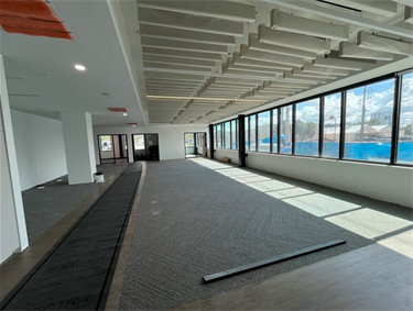 open office area with large windows and grey floors 