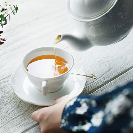 Person pouring water into tea cup