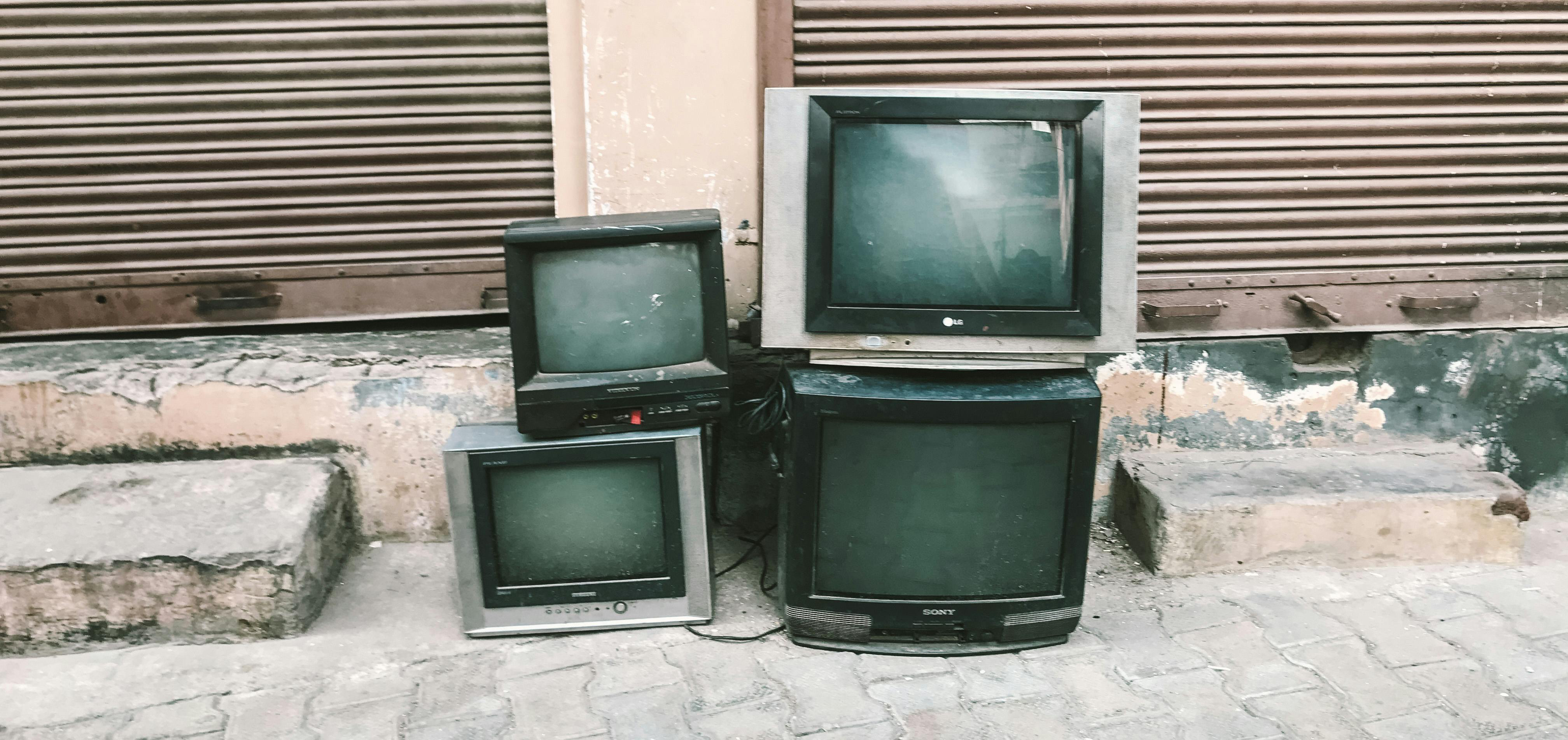 Electronic waste stack of TVs on ground