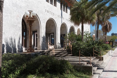 a historic post office building with landscaping outside