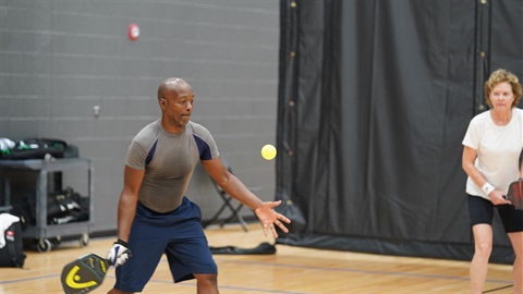 a man hitting a pickleball at a recreation center