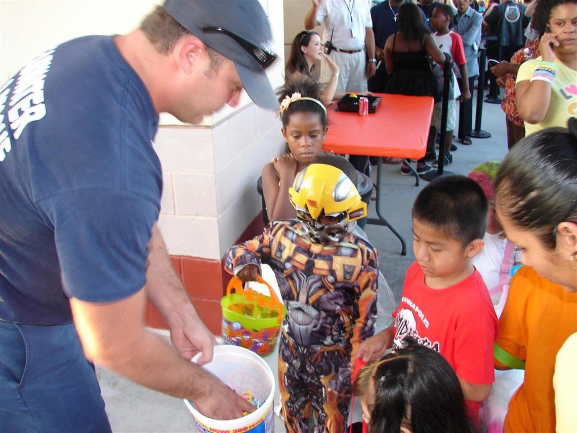 Firefighter handing out candy to kids in costumes