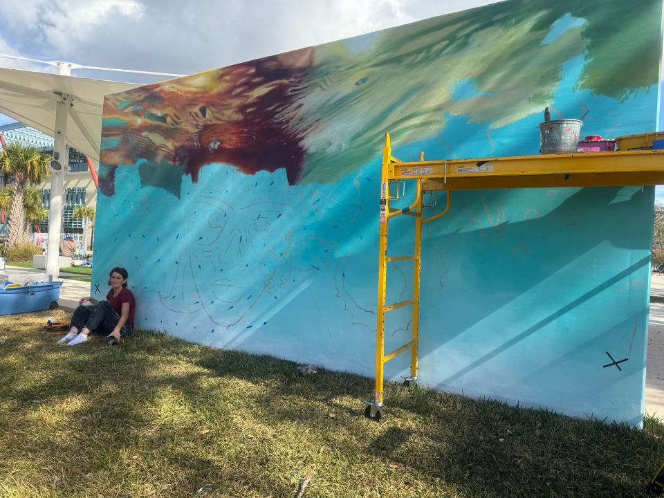 Outside wall mural being painted by artist.