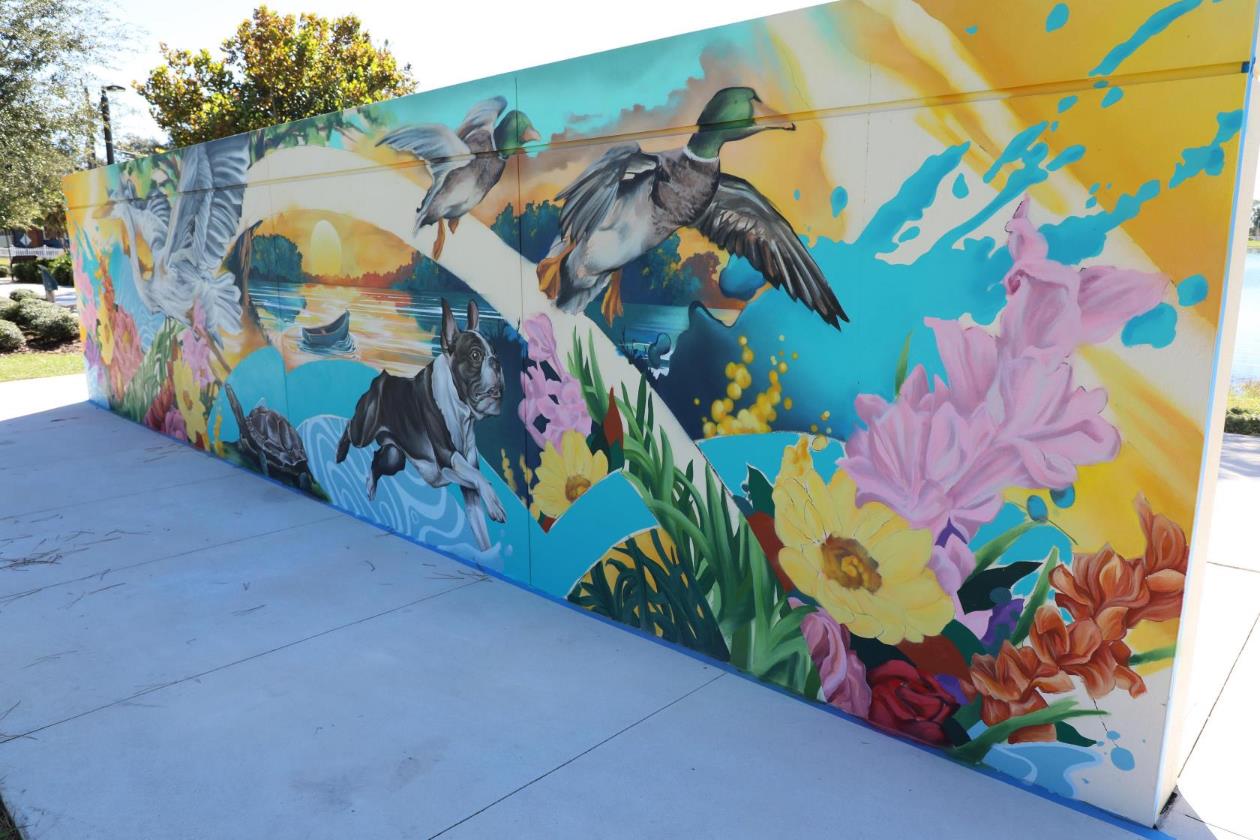 Outdoor wall mural of birds and flowers.