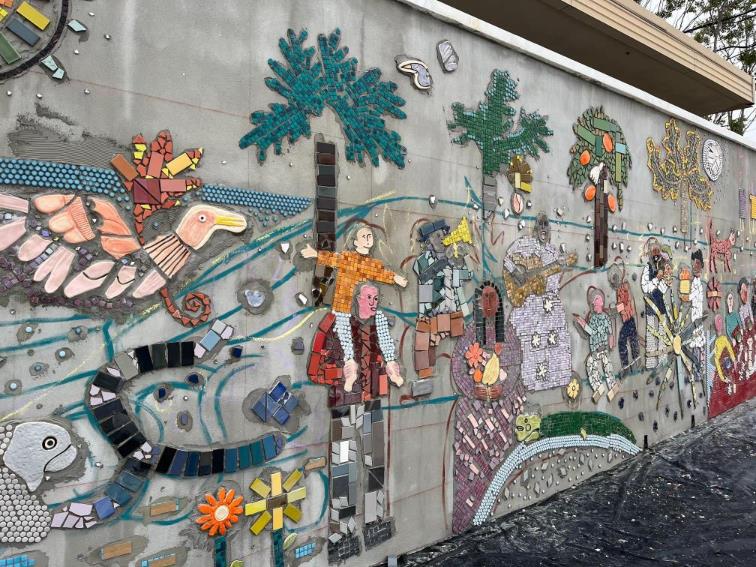 Outdoor wall mural of families in a mosaic.