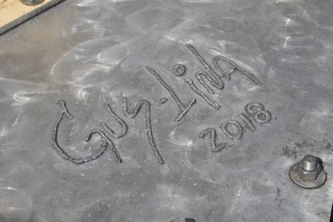 Image of artists signature in cement sidewalk