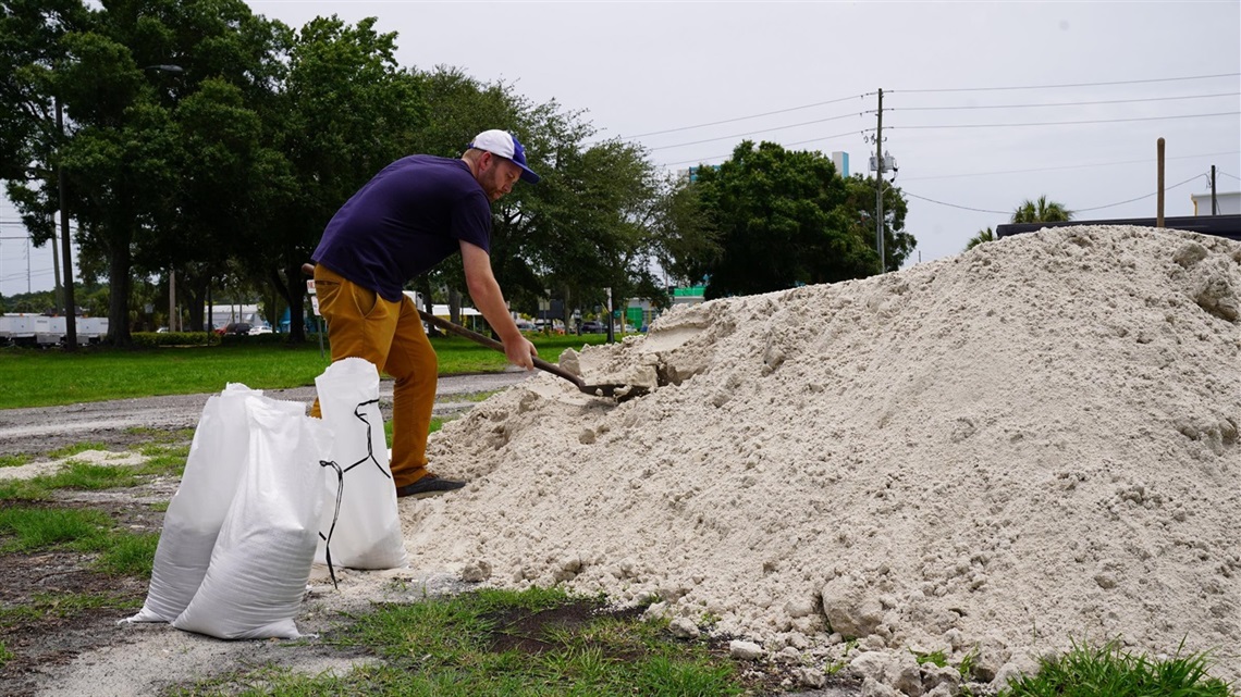 person scooping sandbags